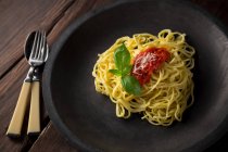 Спагетти с соусом и базиликом на тарелке — стоковое фото