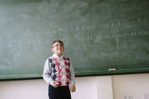 Маленька дитина стоїть на дошці в класі — стокове фото
