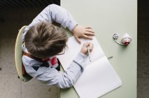Маленький мальчик пишет для копирования книги — стоковое фото