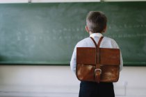 Мальчик со школьной сумкой в классе — стоковое фото
