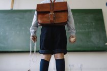 Boy with schoolbag in classroom — Stock Photo