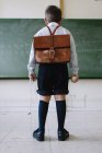 Boy with schoolbag in classroom — Stock Photo