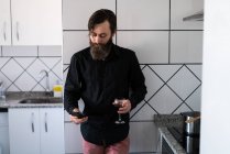 Homem com telefone e vinho — Fotografia de Stock