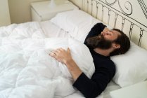 Homme barbu couché dans son lit — Photo de stock