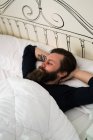 Bärtiger Mann liegt im Bett — Stockfoto