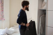 Man choosing shirt in morning — Stock Photo