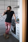 Чоловік п'є вино на кухні — стокове фото