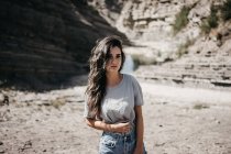 Jeune femme debout à la falaise — Photo de stock