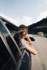 Woman looking back from car window — Stock Photo