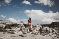 Junge Frau sitzt auf Felsen — Stockfoto