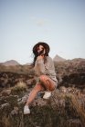 Donna in giorno ventoso su roccia — Foto stock