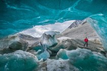 Dentro da caverna de gelo e viajante fora — Fotografia de Stock
