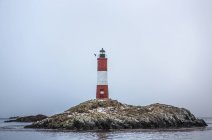 Lighthouse on rocky island — Stock Photo