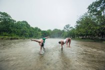 Мужчины танцуют на земле под дождем — стоковое фото