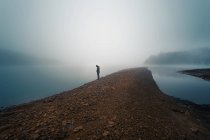 Anonymous person on misty shore — Stock Photo