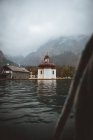 Igreja em costa de lago em montanhas — Fotografia de Stock