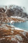 Persona en la orilla rocosa en las montañas - foto de stock