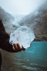 Persona anonima che tiene un pezzo di ghiaccio — Foto stock