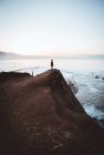 Человек на скале на берегу моря — стоковое фото