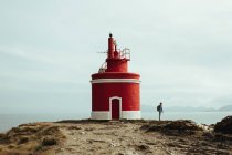 Tourist and lighthouse on coastline — Stock Photo