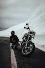 Человек с мотоциклом возле ледника — стоковое фото