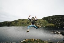 Backpacker saltare sul paesaggio — Foto stock