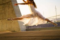 Bailarina de cultivos saltando en el aire en el parque urbano - foto de stock