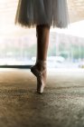 Низька секція балерини в точковому взутті та сукні, що стоїть на пальцях ніг — стокове фото
