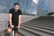Garçon en noir sur vélo — Photo de stock