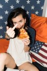 Female holding pizza slice and showing fuck — Stock Photo