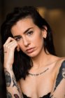 Young brunette with tattooed posing — Stock Photo
