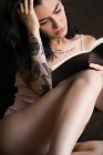 Jovem tatuado mulher leitura livro — Fotografia de Stock