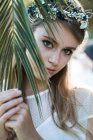 Menina macia atrás da folha de palma — Fotografia de Stock