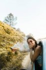 Chica posando en coche con bomba de humo - foto de stock