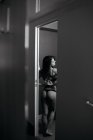Vista posteriore della sensuale donna bruna in lingerie nera che si spoglia . — Foto stock