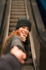 Porträt eines fröhlichen Mädchens, das die Hand eines Fotografen hält und in die Kamera blickt — Stockfoto