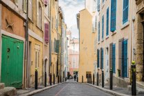 Distant view of woman walking in old city street — Stock Photo