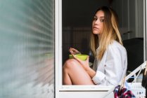 Young thoughtful woman having breakfast — Stock Photo