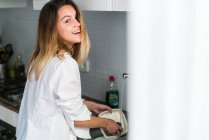 Mulher alegre lavar pratos — Fotografia de Stock