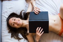 Laughing topless girl covering with book — Stock Photo