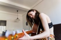 Girl playing guitar at home — Stock Photo
