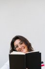 Sonriente chica sosteniendo libro - foto de stock