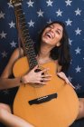 Усміхнена жінка з гітарою — стокове фото