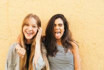 Teen girlfriends posing on yellow — Stock Photo