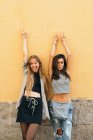 Teen girlfriends posing with arms up — Stock Photo