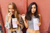 Pretty girls with popcorn paper bags — Stock Photo