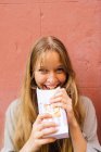 Sonriente chica rubia comiendo palomitas de maíz - foto de stock