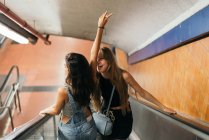 Fröhliche junge Mädchen auf Rolltreppe — Stockfoto