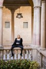 Attraktive Frau sitzt am Geländer — Stockfoto