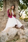 Stilvolle Frau sitzt auf einem Baum — Stockfoto